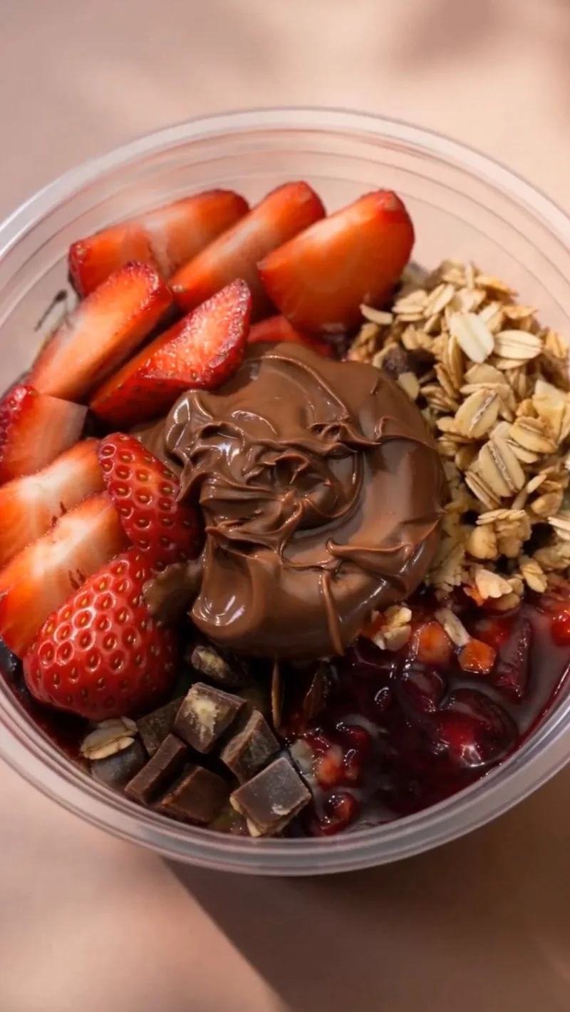 Moonies açaí bowl with strawberries, granola, chocolate and coconut